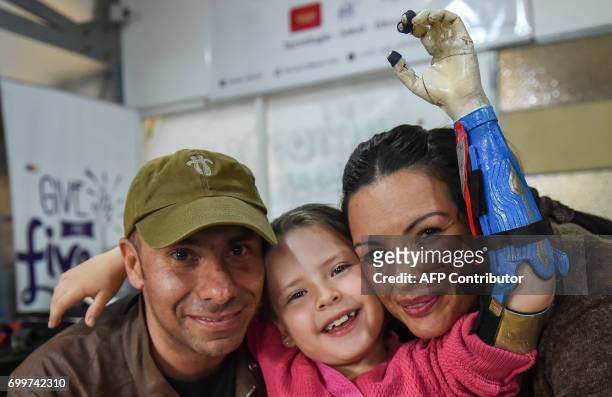 Colombian Shaio Valeria Novas poses with her parents Julia Giraldo and Alexander Novas while trying her 3D printed prosthesis with a superhero...
