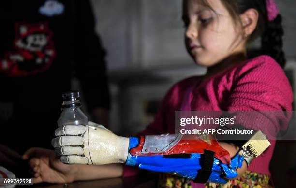 Colombian Shaio Valeria Novas tries her 3D printed prosthesis with a superhero "Wonder Woman" design, in Bogota, Colombia on June 12, 2017. Fabrilab...