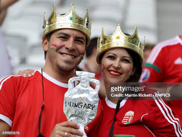 Hungary fans wearing crowns and holding a homemade Euro trophy in the stands