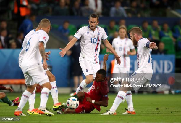 Portugal's Nani wins a free kick after going down under the challenge from Iceland's Gylfi Sigurdsson and Aron Gunnarsson