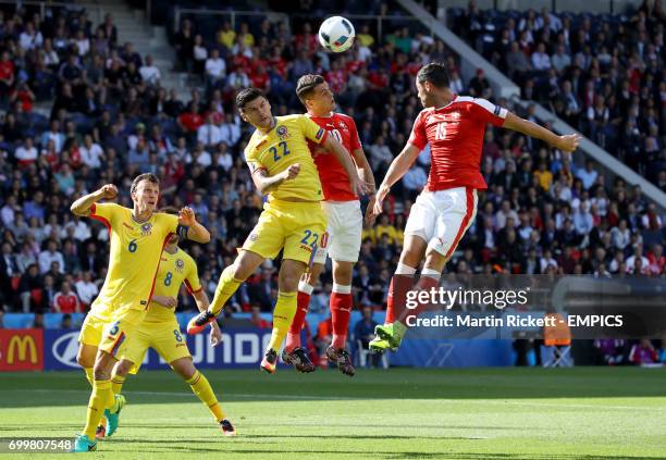 Romania's Cristian Sapunaru battle for the ball in the air with Switzerland's Granit Xhaka and Blerim Dzemaili