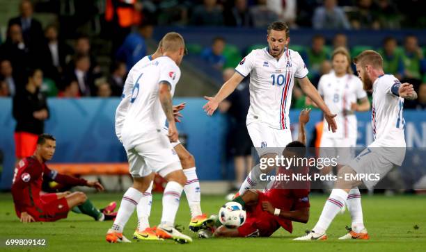 Portugal's Nani wins a free kick after going down under the challenge from Iceland's Gylfi Sigurdsson and Aron Gunnarsson