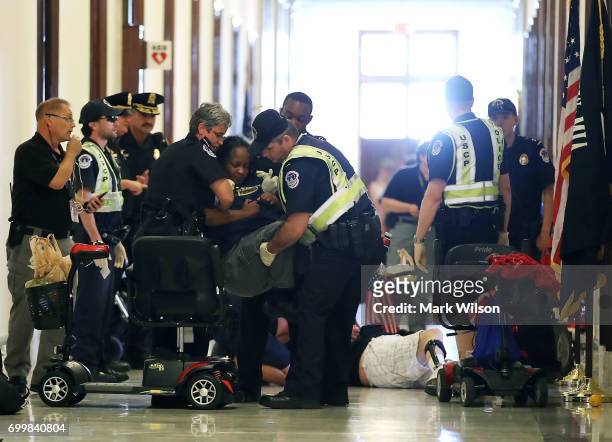 Capitol Police remove protesters from in front of the office of Senate Majority Leader Mitch McConnell inside the Russell Senate Office Building on...