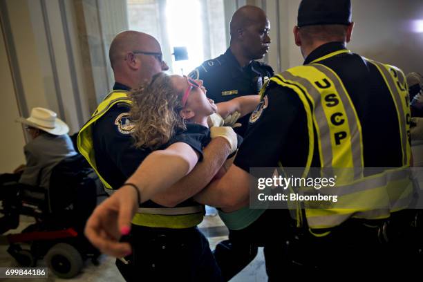 Demonstrator protesting cuts to Medicaid is carried away from the office of Senate Majority Leader Mitch McConnell by U.S. Capitol police officers at...