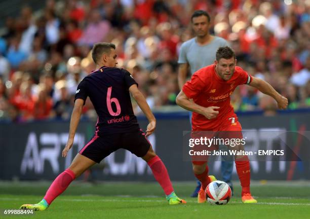 Barcelona's Denis Suarez and Liverpool's James Milner battle for the ball