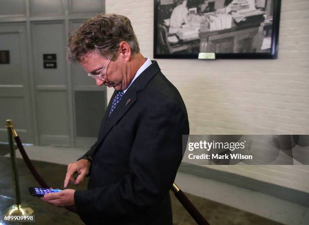 Sen. Rand Paul checks his messages before speaking to the media about the Senate Republican health care bill proposal, on June 22, 2017 in...