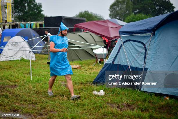 Festival goer walks on the muddy camping compound ahead the Hurricane Festival 2017 on June 22, 2017 in Scheessel, Germany. The area of the festival...
