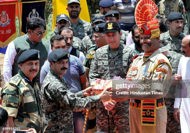 Border security force soldier accepts sweets from the Pakistan SailKot sector commander Brig. Amjad Hussain during the ancient shrine of Dalip Singh...