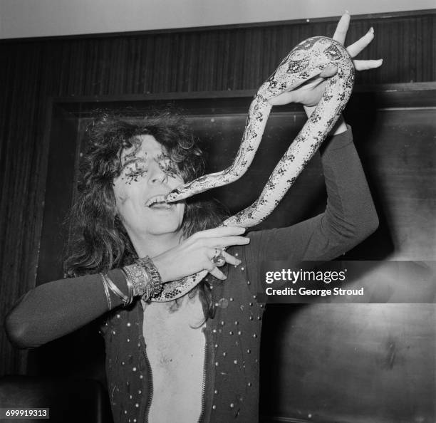 American singer and songwriter Alice Cooper with his 6-foot python, UK, 21st October 1971.