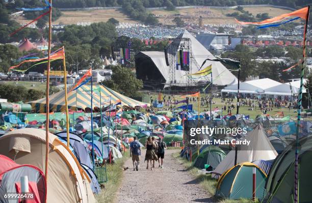 People walk towards the Pyramid Stage at the Glastonbury Festival site at Worthy Farm in Pilton on June 22, 2017 near Glastonbury, England. The...