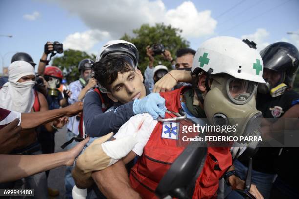 Seemingly unconscious demonstrator hit by a rubber bullet shot by riot police is carried away by volunteer medics as opposition activists and riot...