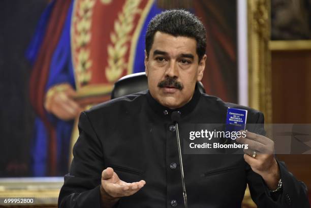 Nicolas Maduro, president of Venezuela, holds up a copy of the Venezuelan constitution during a press conference in Caracas, Venezuela, on Thursday,...