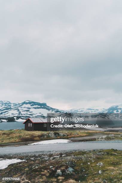 hut in de buurt van het meer in de besneeuwde bergen in noorwegen - shack stockfoto's en -beelden