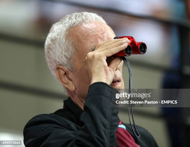 West Ham United fan uses binoculars to watch the game