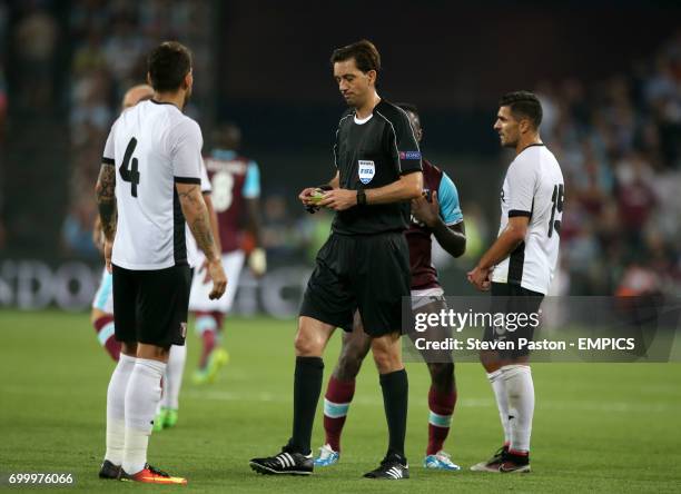 Match referee Mauel Grafe hands out a yellow card