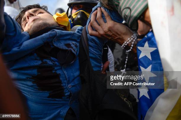 An apparently unconscious demonstrator hit by a rubber bullet shot by riot police is carried away by volunteer medics as opposition activists and...