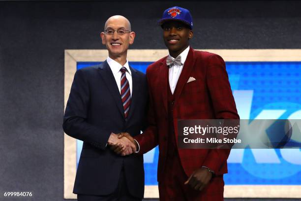 Frank Ntilikina walks on stage with NBA commissioner Adam Silver after being drafted eighth overall by the New York Knicks during the first round of...