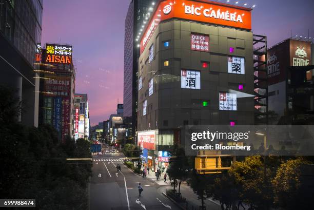 Pedestrians walk past the Bic Camera Akiba electronics store, operated by Bic Camera Inc., at night in the Akihabara district of Tokyo, Japan, on...