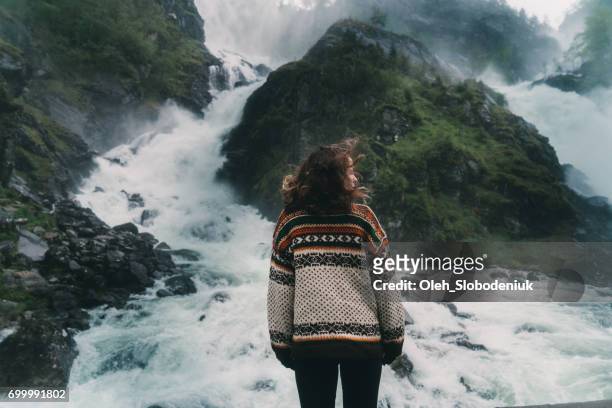 woman looking at låtefossen waterfall in mountains in norway - waterfalls stock pictures, royalty-free photos & images