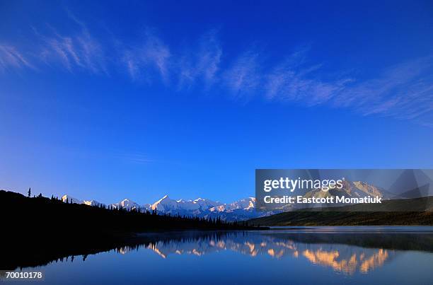 snow-covered mountain reflected in lake - wonder lake stock pictures, royalty-free photos & images