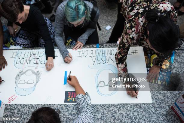 People write messages for Nabra Hassanen, Philando Castile, and Charleena Chavon during a candlelight vigil for victims of hate crimes and state...