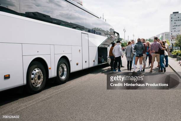 large group of tourist waiting to get on bus - autobus stock pictures, royalty-free photos & images