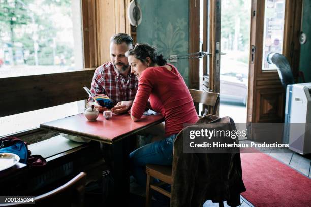 Couple in Cafe reading Tour Guide