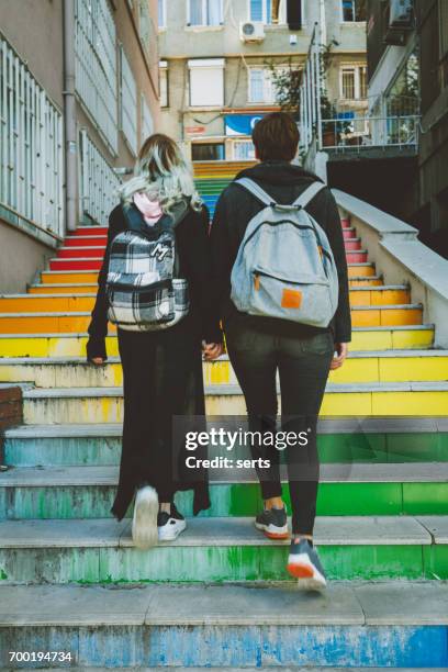 stedelijke lesbisch koppel lopen op straat - couple school stockfoto's en -beelden