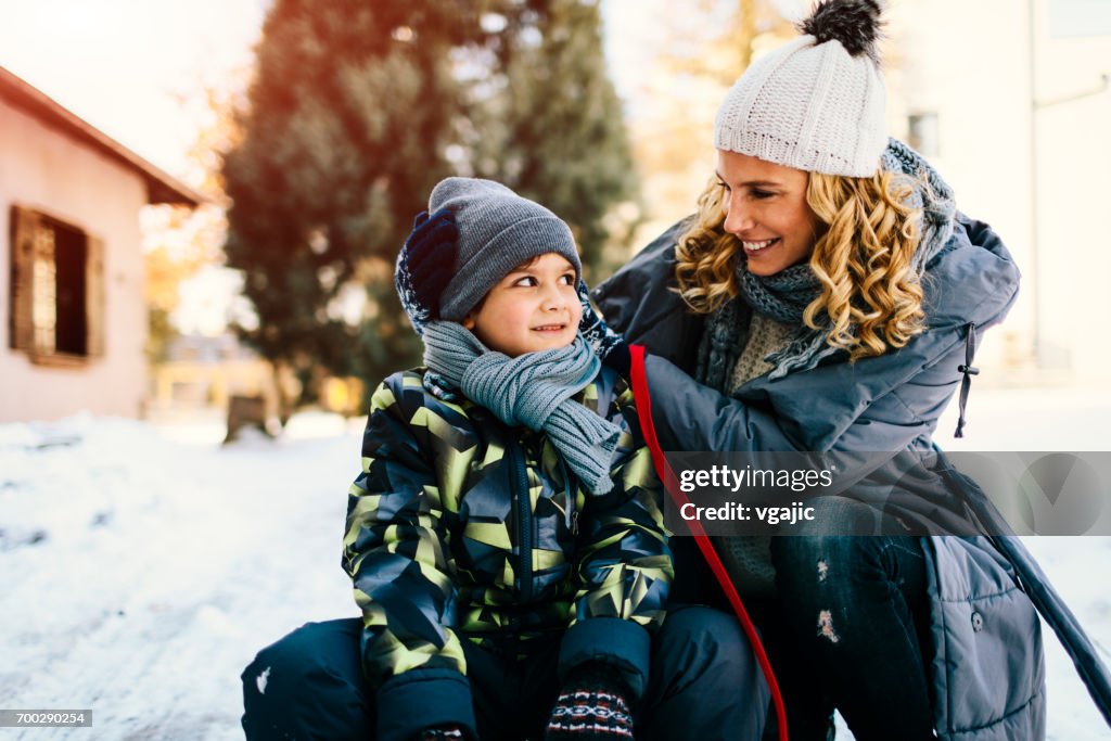 Mãe e filho se divertindo ao ar livre no inverno