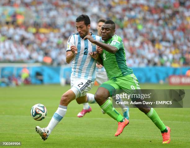 Nigeria's Emmanuel Emenike and Argentina's Ezequiel Garay battle for the ball