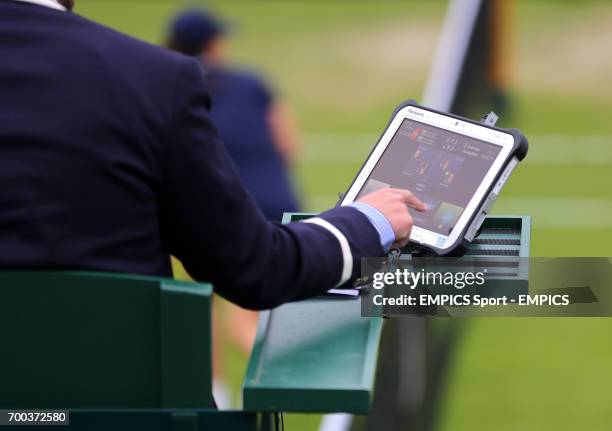 An umpire uses his computer on his chair