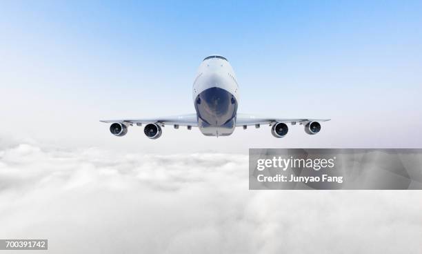 passenger jet airplane over clouds - flugzeug seitlich himmel stock-fotos und bilder