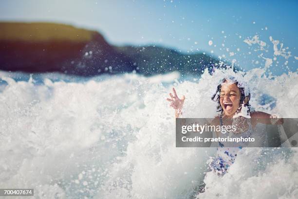 girl is jumping and playing in the ocean in the big waves - splash stock pictures, royalty-free photos & images