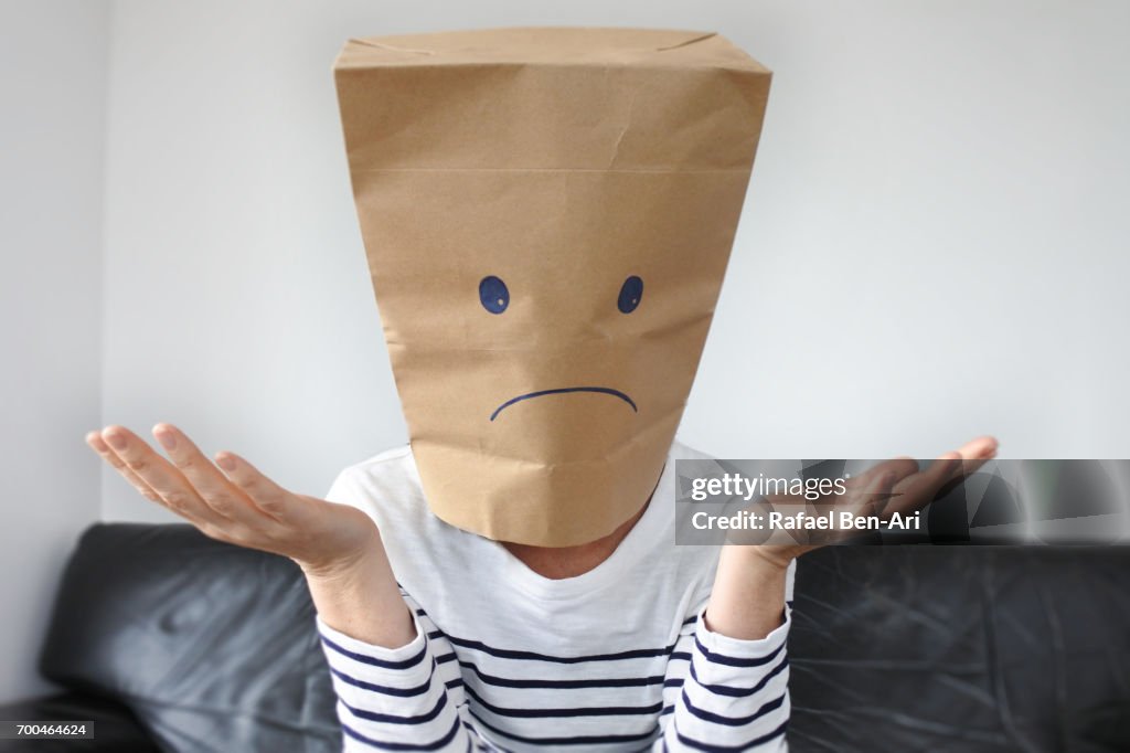 Anonymous sad woman sitting on a couch