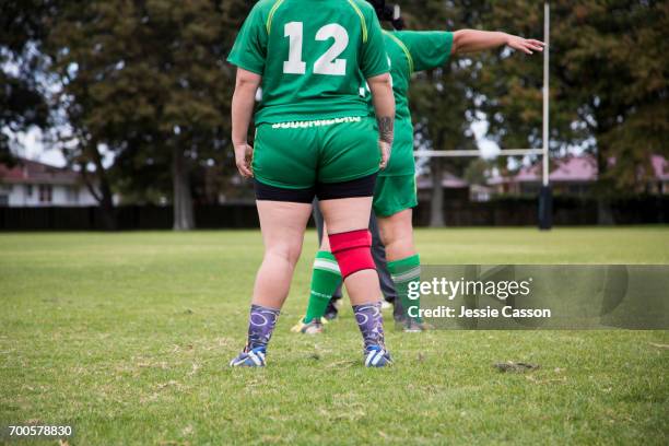 female rugby players on field standing with back to camera - rugby shirt stock pictures, royalty-free photos & images