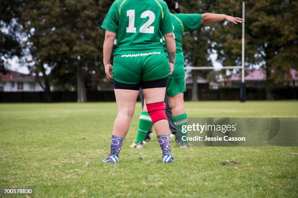 female rugby players on field standing with back to camera - female rugby new zealand stock pictures, royalty-free photos & images