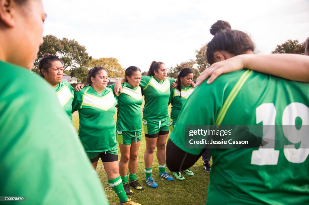 Female rugby players have team talk at side of pitch