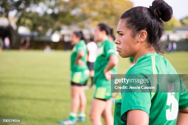 female rugby players stand at edge of field watching match - grittywomantrend stock pictures, royalty-free photos & images