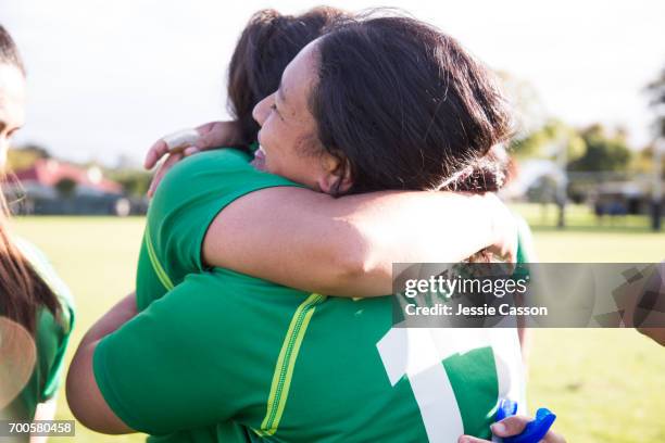 two female rugby players embrace after match - grittywomantrend stock pictures, royalty-free photos & images