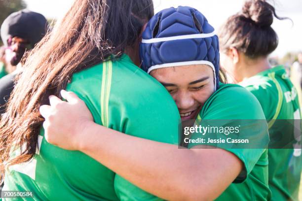 two female rugby players embrace after match - grittywomantrend stock pictures, royalty-free photos & images