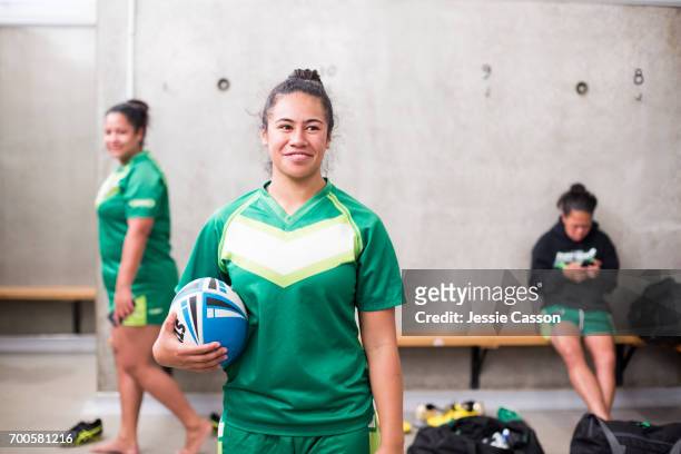female rugby player in changing rooms holding ball - rugby sport foto e immagini stock