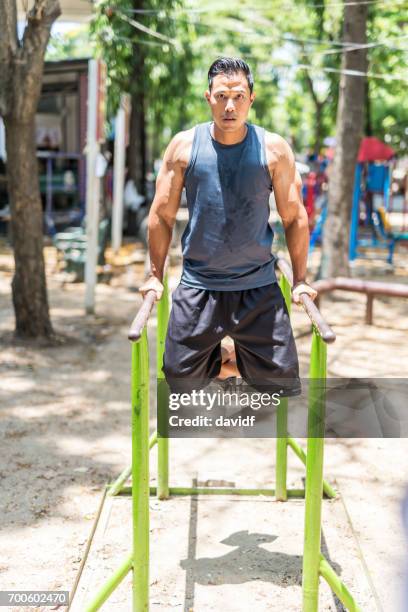 asian man lifting weights at a makeshift outdoor gym - makeshift weights stock pictures, royalty-free photos & images