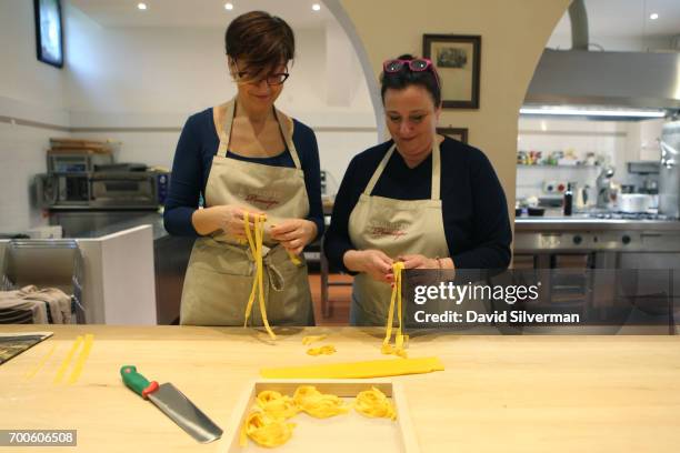 Barbara Zaccagni and Valeria Hensemberger show a visiting tourist how to make fettuccine during a private cooking lesson at Il Salotto di Penelope on...