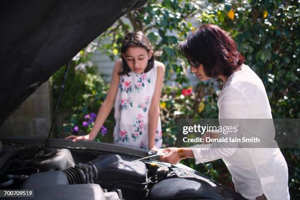 mother teaching daughter about car engine - dipstick stock pictures, royalty-free photos & images