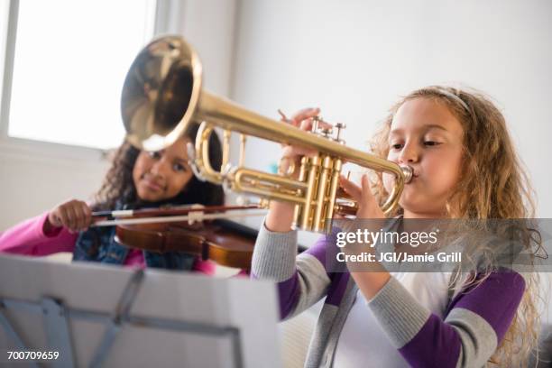 girls practicing playing violin and trumpet - girl band stock pictures, royalty-free photos & images