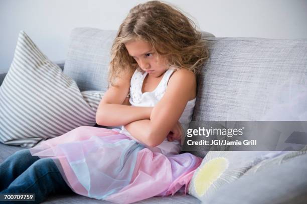 frustrated girl wearing tutu pouting on sofa - dickköpfig stock-fotos und bilder