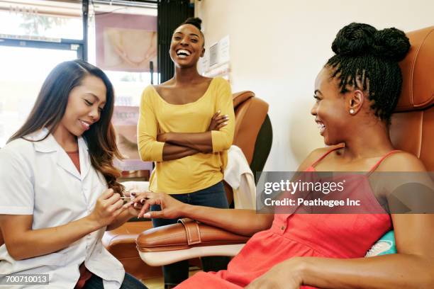 business owner assisting customer in nail salon - black painted toes stock-fotos und bilder