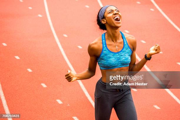 happy black athlete celebrating on track - 叫ぶ ストックフォトと画像