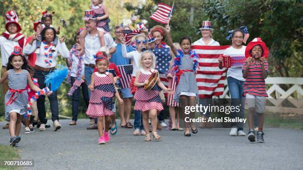 people marching in 4th of july parade in park - america parade stockfoto's en -beelden