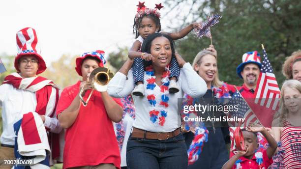 people marching in 4th of july parade in park - small town parade stock pictures, royalty-free photos & images